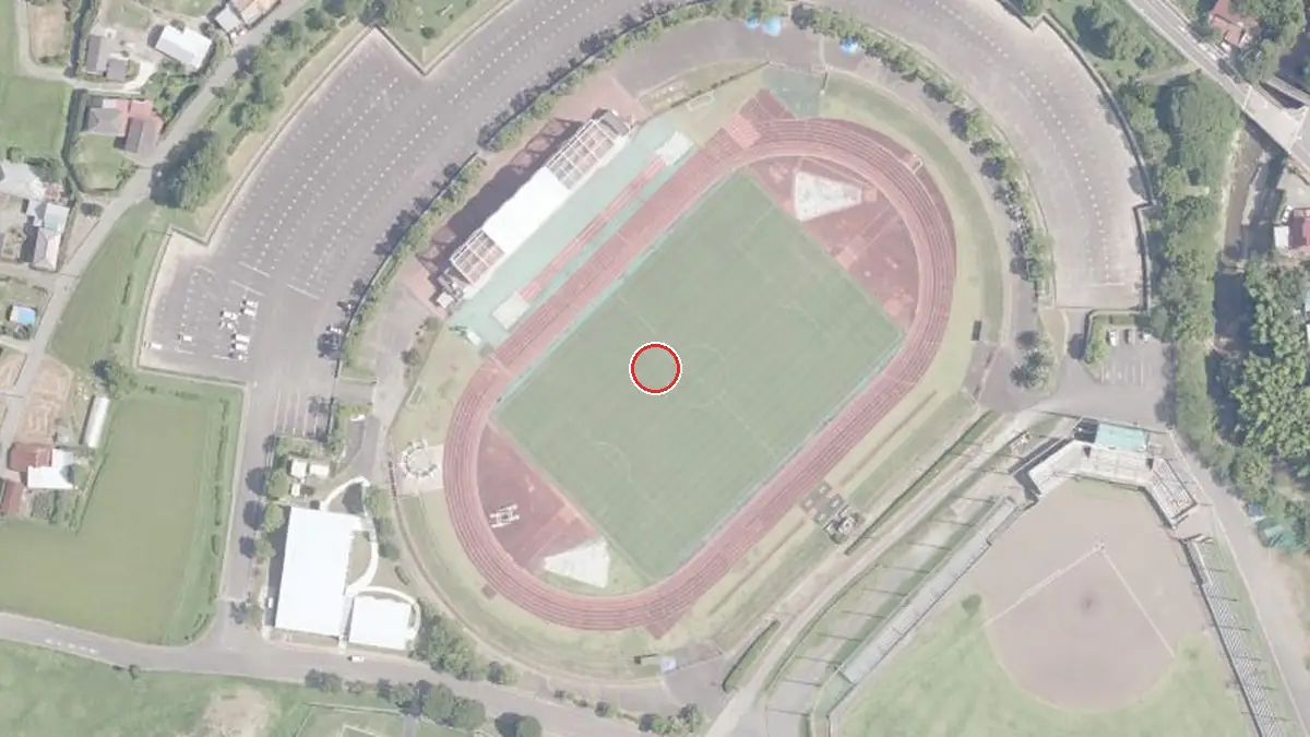 上空から見た鴨川市陸上競技場（中心の赤い輪が会場の位置）