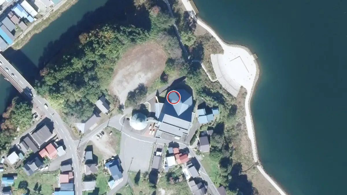 上空から見た西和賀町文化創造館 銀河ホール（中心の赤い輪が会場の位置）