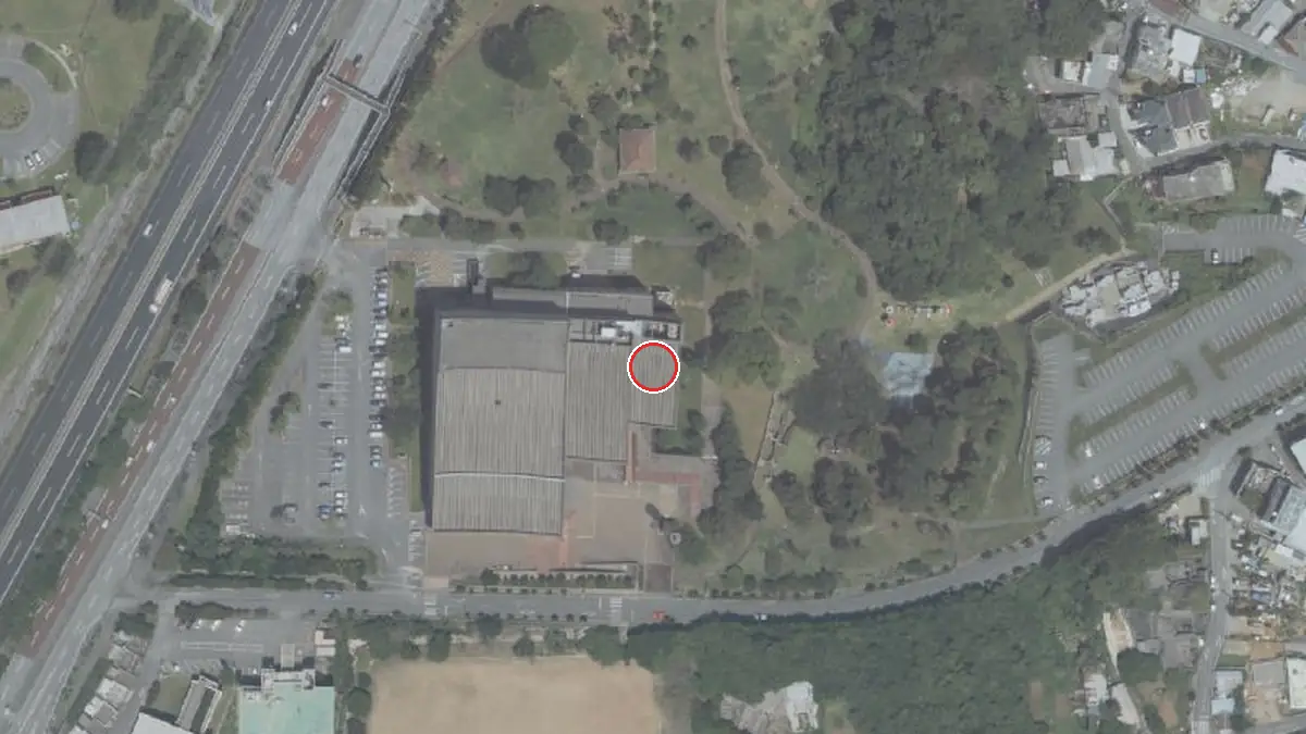 上空から見た沖縄市立中央公民館（中心の赤い輪が会場の位置）