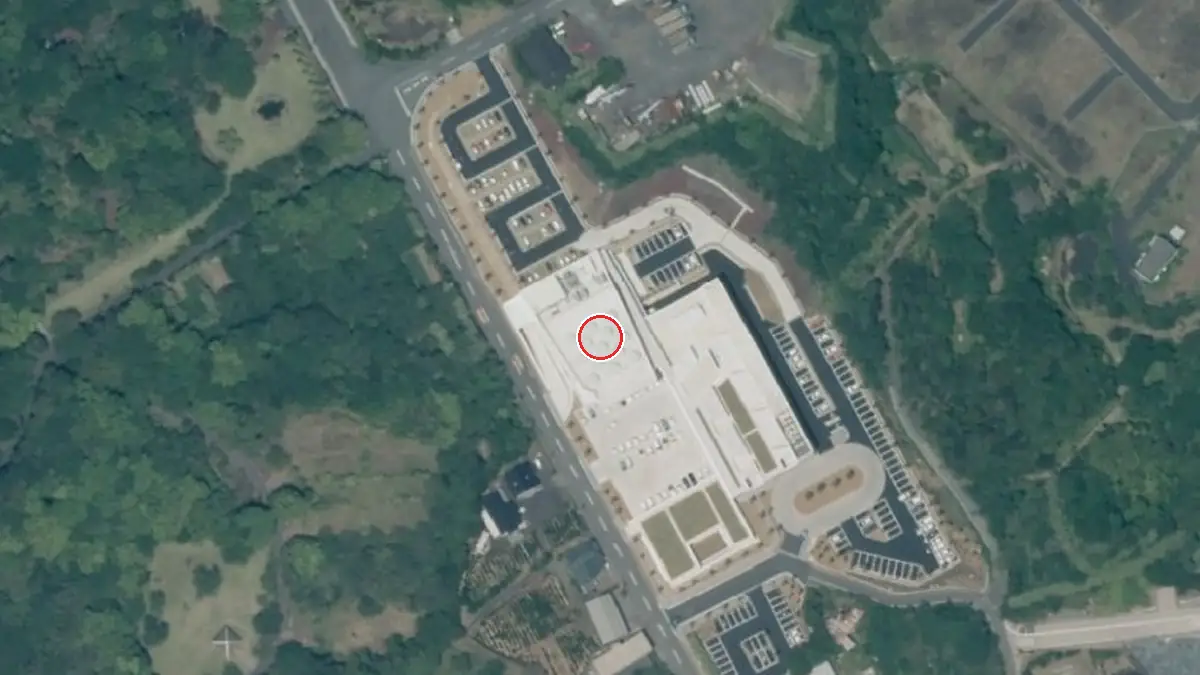 上空から見た八丈町多目的ホール「おじゃれ」（中心の赤い輪が会場の位置）