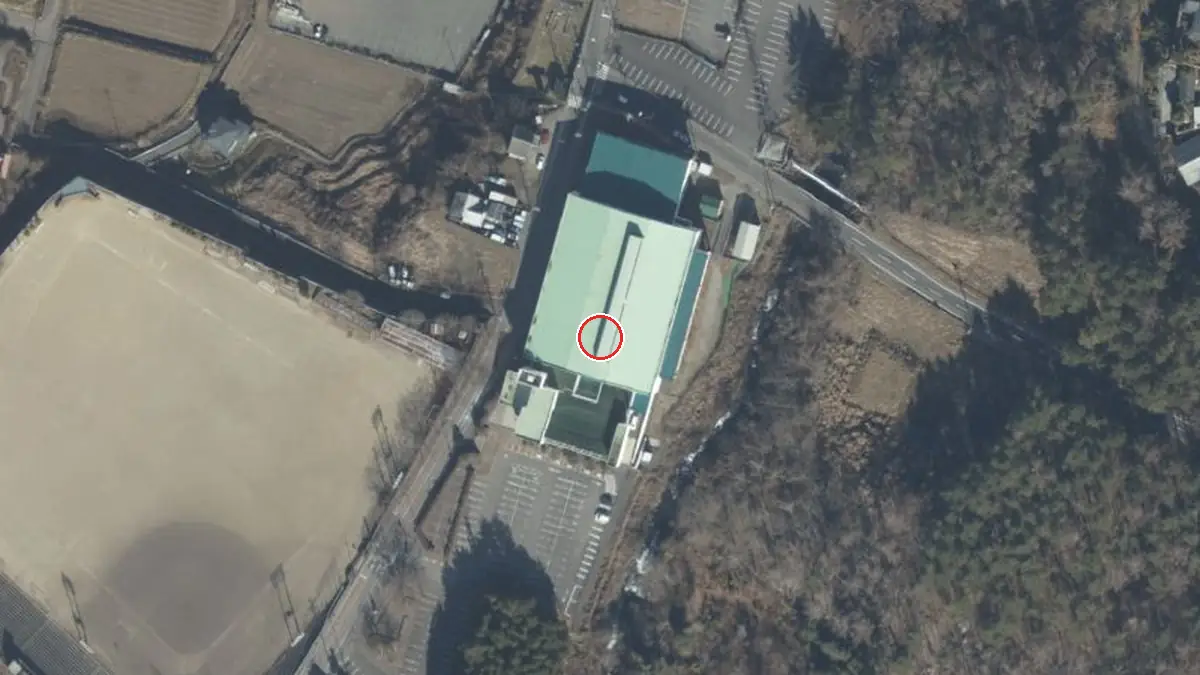 上空から見た鐘山スポーツセンター体育館（中心の赤い輪が会場の位置）